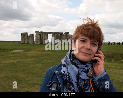 Woman tourist listens to audio guide at Stonehenge, Wiltshire, England, May 16, 2012, © Katharine Andriotis Stock Photo