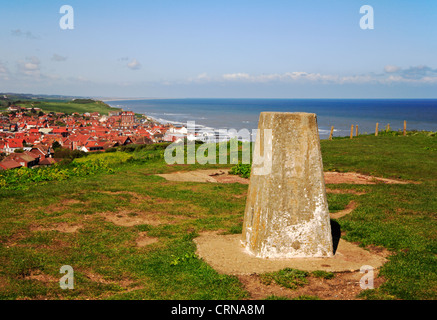 A trig point on Beeston Bump with a view of the coastal town of Sheringham, Norfolk, England, United Kingdom. Stock Photo