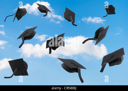 Graduation mortar boards thrown into a blue sky Stock Photo