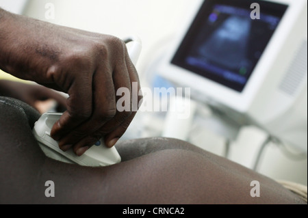 A Radiographer applies pressure to the abdominal region to get a clearer picture from the ultrasound. Stock Photo