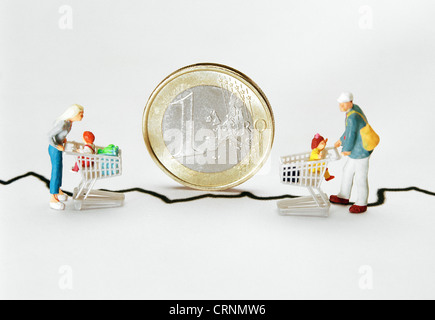 Miniature figures in front of a standing Euromuenze Stock Photo