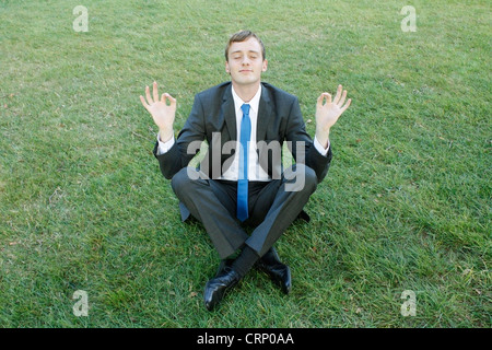 A business man doing yoga in the park Stock Photo