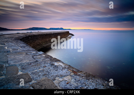 Sunrise over 'The Cobb', a harbour wall that allowed Lyme Regis to become a major port from the 13th century onwards. Stock Photo