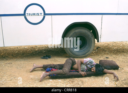 Attendant sleeping near a tourist bus ( India) Stock Photo