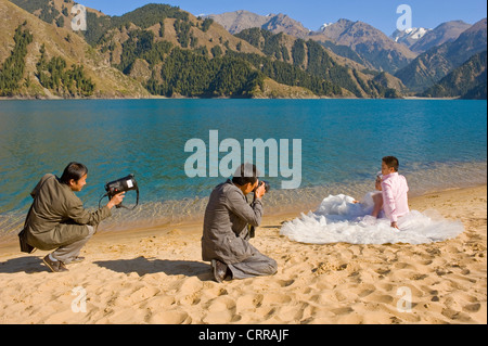 A Chinese couple pose for their wedding photographs at the popular alpine beauty spot of Heavenly Lake. Stock Photo