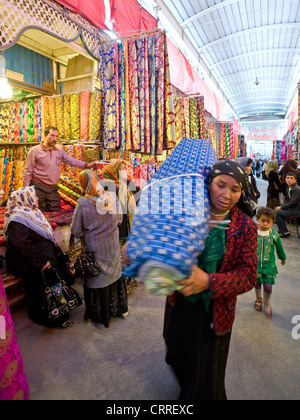 Uyghur Chinese people and colourful rolls of silk fabric in the Western-Central Asia Market ( Bazaar) of Kashgar. Stock Photo