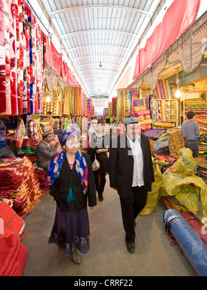 Uyghur Chinese people and colourful rolls of silk fabric in the Western-Central Asia Market ( Bazaar) of Kashgar. Stock Photo