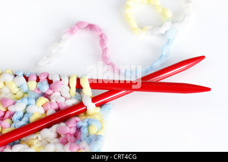 Beautiful baby or arts and crafts background with red needles with pastel or baby colors wool or yarn. Stock Photo
