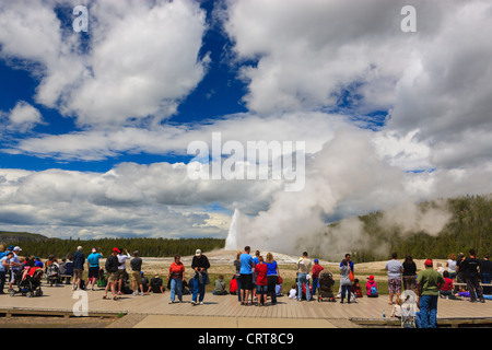People watching Old Faithfull geyser in Yellowstone National Park, Wyoming, USA Stock Photo