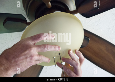 Male hands shown installing a ceiling fan Stock Photo