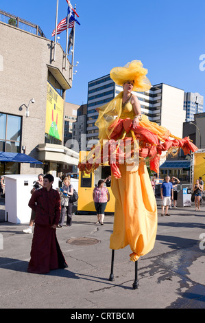 Stilt artist walking amongst people during the Just for Laughs festival in Montreal, Quebec, Canada. Stock Photo