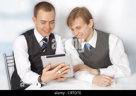 Portrait of two smart young businessmen looking at clipboard computer Stock Photo