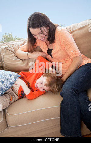 Mother and son playing on a couch. Stock Photo