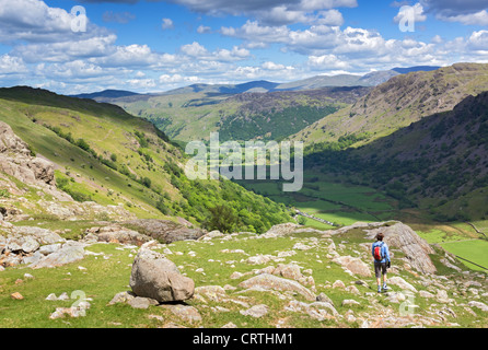 A hiker approaches Seathwaite via Sour Milk Gill on a sunny day in the Lake District, UK. Stock Photo