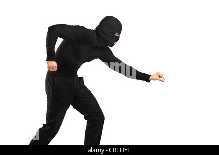 A man in robbery mask trying to steal something isolated on white background Stock Photo