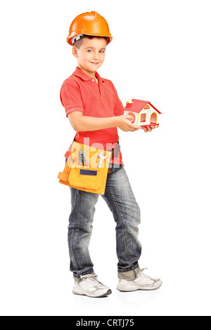 Full length portrait of a child with helmet holding a model of house isolated on white background Stock Photo