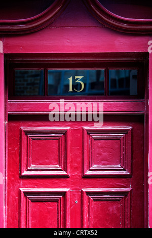 Number 13 on a pink red front door London, England