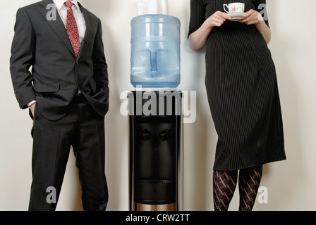 Two people standing at the watercooler. Stock Photo