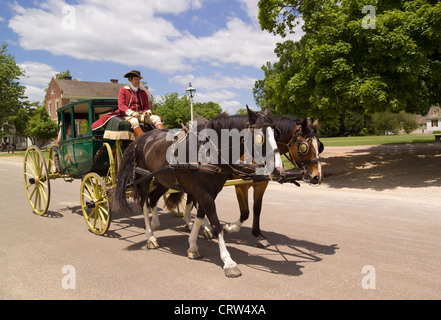 Tourists enjoy a leisurely horse-drawn carriage ride through the wide streets of historic 18th-century Colonial Williamsburg in Virginia, USA. Stock Photo