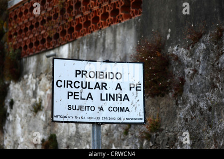 Sign in Portuguese warning not to walk on railway tracks, subject to fine , Vila Praia de Ancora , northern Portugal Stock Photo