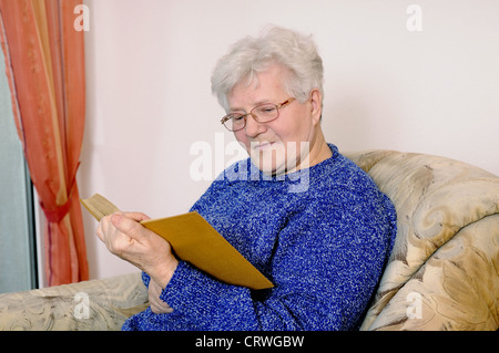 elderly woman reads a book Stock Photo