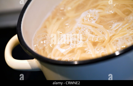 Boiling water with noodles in the pan Stock Photo