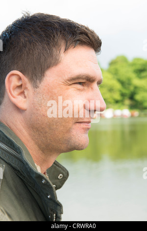 Close up of man looking at the scenery  by a lake Stock Photo