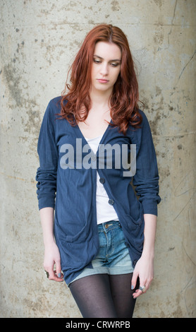 Serious young female adult with red hair looking pensive Stock Photo