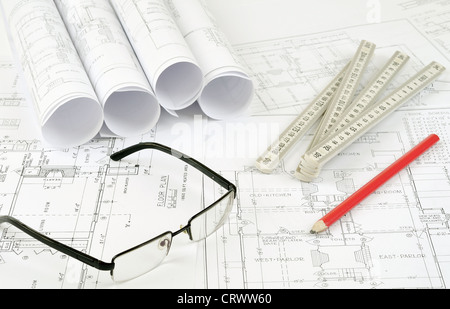roled up plans on the table with glasses measure and pencil Stock Photo