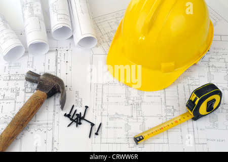 Yellow hard hat and heap of project drawings Stock Photo
