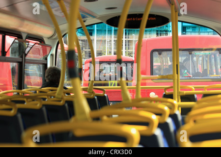 a view along the top deck of a London double decker bus including other buses traveling in front Stock Photo