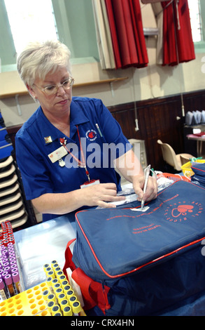 A NHS National Blood Service nurse packs blood donated at a collection center into storage bag. Stock Photo