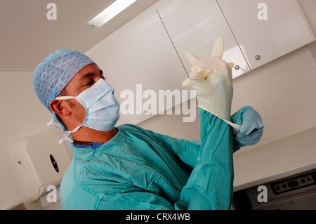 Doctor putting on rubber gloves Stock Photo