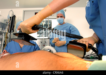 Doctors using a defibrillator to resuscitate a male heart attack victim. Stock Photo