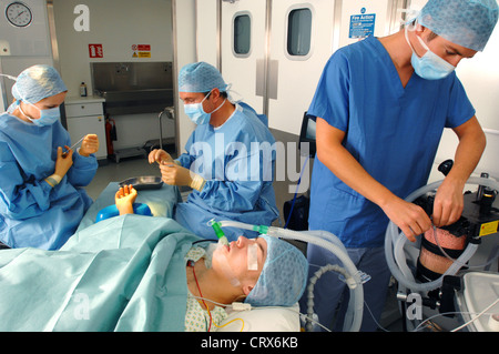 Surgeon, anesthetist and nurse perform an operation on the hand of a female patient. Stock Photo