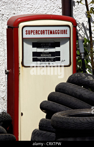 Old disused petrol pump with old car and bike tyres, Prien Upper Bavaria Germany Stock Photo