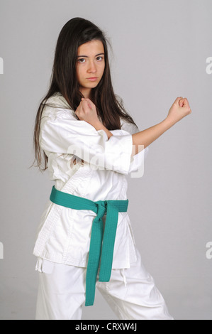 girl in Karate moves on grey background Stock Photo