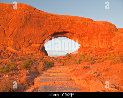 Warm sunset light on stairs to North Window Arch in Arches National Park. Stock Photo