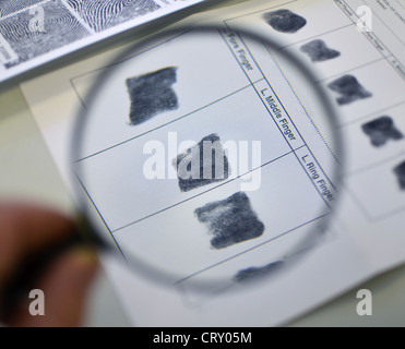 Looking at elimination finger prints through a magnifying glass Stock Photo