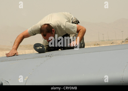 Staff Sgt. Dustin Elizono, a C-130 crew chief from the 317th Aircraft Maintenance Squadron at Dyess Air Force Base, Texas, currently assigned to the 451st AMXS at Kandahar Airfield, Afghanistan, walks along the top of a C-130 during an inspection on July 4, 2012. Stock Photo