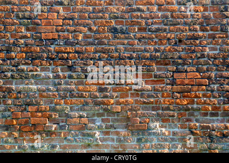 an old red brick wall with damaged bricks and mortar Stock Photo