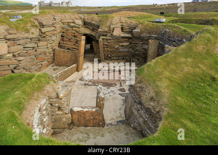 Excavations of primeval dwelling with connecting passage in prehistoric Neolithic village at Skara Brae Orkney Islands Scotland Stock Photo