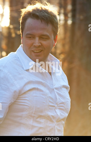 Happy active man age 40 playing outside highlighted by sun. Champlin Minnesota MN USA Stock Photo