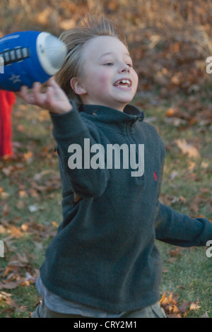 Boy age 9 passing football in backyard touch football game. Champlin Minnesota MN USA Stock Photo
