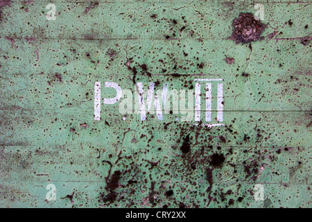 Detail of a weathered concrete wall with P.W. III painted on it at an industrial facility. Stock Photo