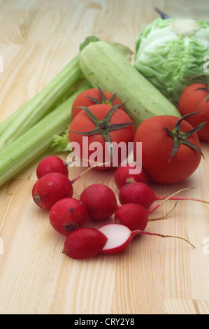 fresh raddish and vegetables over pine wood table closeup Stock Photo