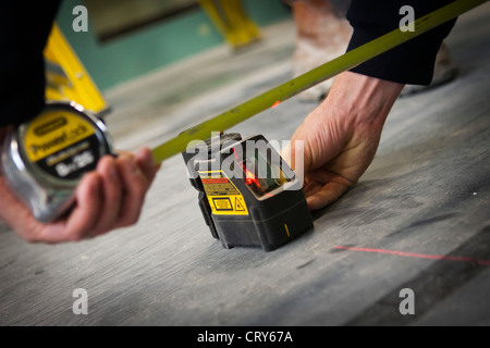 builders using a cross line laser Stock Photo