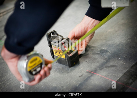 Builders using cross line laser Stock Photo