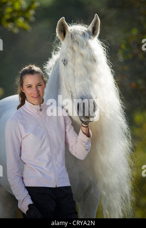 Pure Spanish Horse Andalusian Young woman standing next to the stallion Caprichiosa Stock Photo