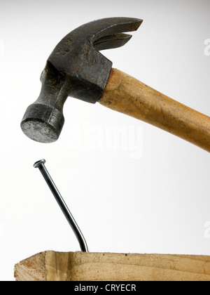 A hammer in close proximity to bent nail in piece of timber Stock Photo